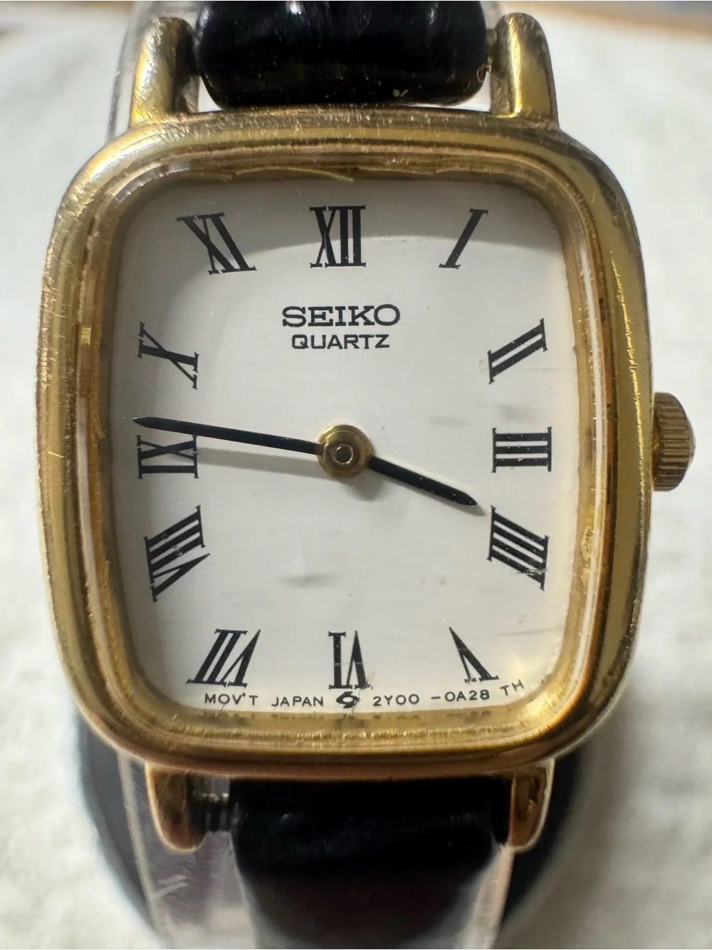 Seiko Gold Tone Case Watch with White Dial and Black Strap woman’s watch